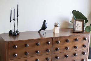 une commode avec une statue d'oiseau noir dessus dans l'établissement The Poet Den with 120 inch screen, à Yas Island