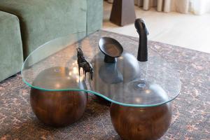 une table en verre avec deux vases sur une table dans l'établissement The Poet Den with 120 inch screen, à Yas Island