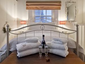 een bed met handdoeken en wijnglazen op een tafel bij Thimble Cottage in St Bees