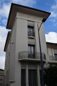ein weißes Gebäude mit Balkon und Straßenbeleuchtung in der Unterkunft Villa Meyer Demeure Remarquable chambre d'hôtes standing indépendante in Béziers + 65 Fotos