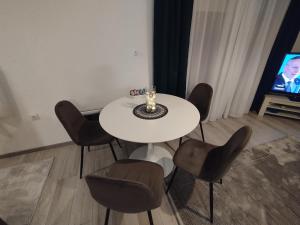 a white table and chairs in a room with a tv at Old Town in Livno