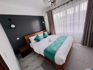 a bedroom with a large bed with blue pillows at Safari Cozy Homes in Nairobi