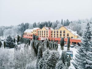 马特劳森蒂姆赖Hotel Narád的一座拥有雪覆盖树木的酒店和一座建筑