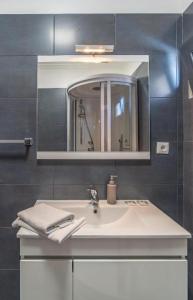 een badkamer met een witte wastafel en een spiegel bij Camara De Lobos Lux Villa in Câmara de Lobos