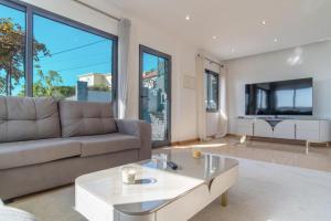 een woonkamer met een bank en een tafel bij Camara De Lobos Lux Villa in Câmara de Lobos