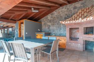 een eetkamer met een tafel en stoelen en een open haard bij Camara De Lobos Lux Villa in Câmara de Lobos
