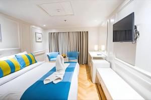 Una habitación de hotel con una cama y un televisor de pantalla plana. en Nile cruise from Luxor to Aswan 4 nights From Aswan to Luxor 3 nights, en Luxor 24 fotos más