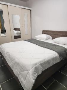 une chambre avec un grand lit avec des draps blancs dans l'établissement Bright apartment 1 to 3 bedrooms, à Besançon