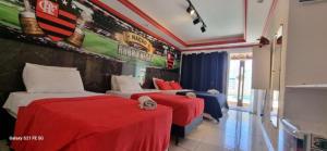 due letti in una stanza con un murale di baseball sul muro di Pousada Bon Vivant a Cabo Frio