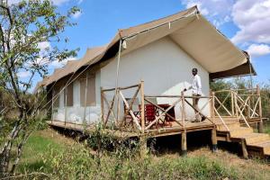 een man die voor een tent staat bij Veilscape Mara Camp in Masai Mara