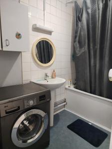 une salle de bains avec lave-linge et lavabo dans l'établissement Bright apartment 1 to 3 bedrooms, à Besançon