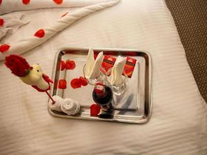 een glazen dienblad met een fles wijn en een drankje bij Selwilliam Hotel Limited in Trofwi +2 foto's
