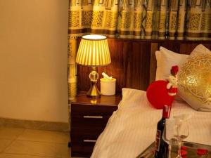 een slaapkamer met een bed met een lamp op een nachtkastje bij Selwilliam Hotel Limited in Trofwi