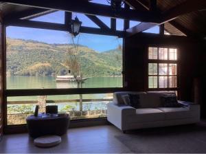 ein Wohnzimmer mit einem großen Fenster und Blick auf einen See in der Unterkunft Angra dos Reis - Píer 600 casa 4 in Angra dos Reis