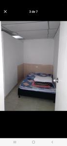 a small room with a bed in a white room at Casa estrella in Manizales