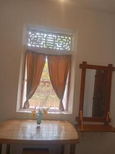 a window with a vase on a table in a room at White Horizon 2 in Ahangama