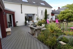 eine Holzterrasse mit einer Bank auf einem Haus in der Unterkunft les prés de la reine in Saint-Doulchard