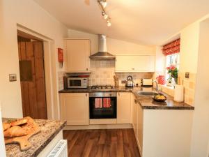a kitchen with a sink and a stove top oven at Beacon Cottage in Pickering