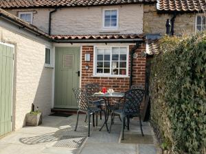 a patio with a table and chairs in front of a house at Beacon Cottage in Pickering