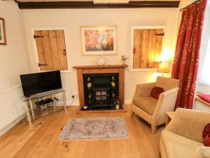 a living room with a fireplace and a television at Beacon Cottage in Pickering