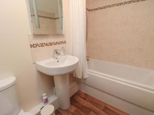 a bathroom with a sink and a toilet and a tub at Beacon Cottage in Pickering +17 photos