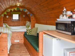 ein kleines Zimmer mit Bett und Mikrowelle in einer Hütte in der Unterkunft Rivendell Glamping Pod - Uk11881 in North Tamerton