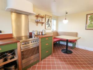 a kitchen with a stove and a table in it at Fronglyd in Cardigan