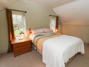a bedroom with a white bed and a window at Fronglyd in Cardigan