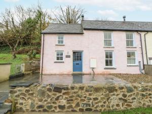 an old pink house with a blue door at Fronglyd in Cardigan