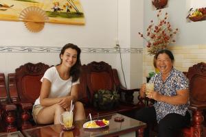 dos mujeres sentadas en sillas con bebidas en Thanh Ha Guesthouse, en Can Tho