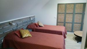 Zimmer mit 2 Betten mit roter Bettwäsche und einem Fenster in der Unterkunft les prés de la reine in Saint-Doulchard