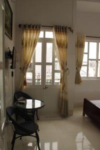 a living room with a table and a window at Thanh Ha Guesthouse in Can Tho