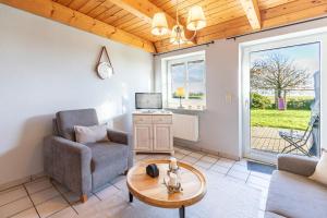 un soggiorno con una sedia e un tavolo di Schipp Landen Frida a Schobüll