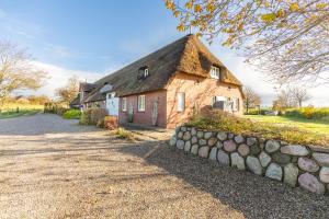 een stenen huis met een stenen muur ervoor bij Schipp Landen Johanna in Schobüll
