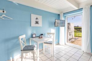 una stanza con un tavolo, delle sedie e una finestra di Schipp Landen Lisa a Schobüll