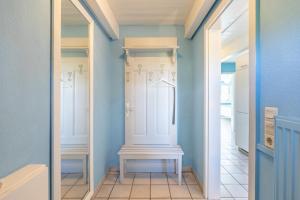 un corridoio con pareti blu e una porta bianca di Schipp Landen Lisa a Schobüll Altre 13 foto