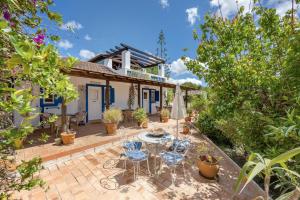 un patio con tavolo e sedie davanti a una casa di Quinta das Achadas - Quartos a Cerro Ruivo Altre 12 foto