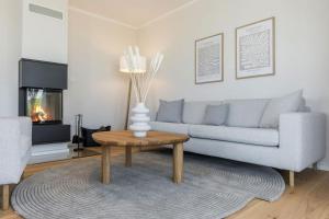a living room with a couch and a coffee table at De Bööi - Luxus-Haus mit Meerblick, Sauna & Kamin in Fehmarn +36 photos