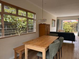 a dining room with a wooden table and chairs at Mimosa Cottage in Cape Town +8 photos
