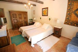 una camera con 2 letti bianchi e un divano di Quinta das Achadas - Quartos a Cerro Ruivo