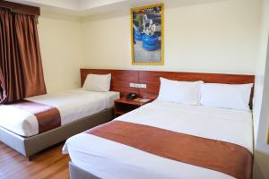 a hotel room with two beds and a window at 456 Hotel in Baguio