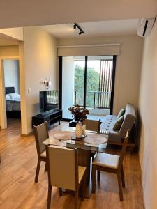 Una sala de estar con una mesa y una habitación con un sofá. en Edificio Spirit Mariscal, en Asunción