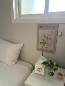 a bedroom with a bed and a window and a plant at GreeneStay Sindang DDP Seoul in Seoul