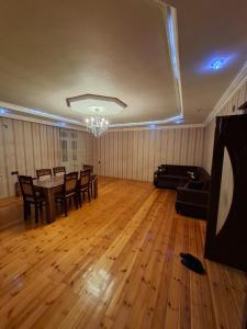 a living room with a table and chairs and a chandelier at Deniz Hotel in Ganja