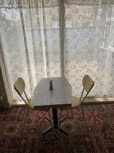 een tafel en twee stoelen voor een raam bij Mickys Bed and Breakfast in Ramsgate +1 foto