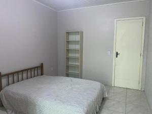 a bedroom with a bed and an open door at Ares de Salinas - 100 metros da praia in Cidreira