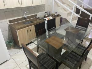 a kitchen with a glass table and a sink at Ares de Salinas - 100 metros da praia in Cidreira