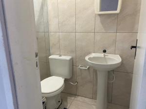 a small bathroom with a toilet and a sink at Ares de Salinas - 100 metros da praia in Cidreira +17 photos