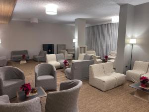a waiting room with chairs and tables and a waiting room at Hotel Union in Folgarida