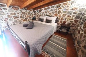 una camera da letto con un letto in un muro di pietra di Markos House a Calimno (Kalymnos)